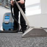 Image of a person using a vacuum cleaner on carpet