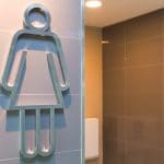 modern public woman toilet sign on granite wall tile at the entrance