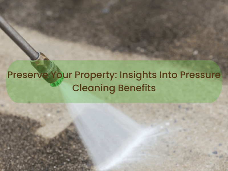 Worker pressure washing a building exterior with water spray, demonstrating professional property cleaning.